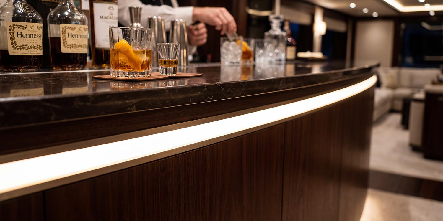 Continuous warm led strip light glowing underneath the counter of a yacht bar